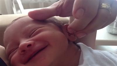 شاهد ابتسامة طفل رضيع تداعبه أمه 