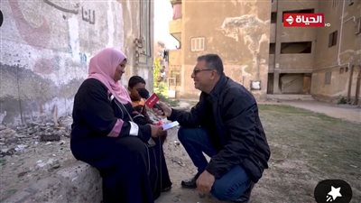 كانت تنتظر أولادها أمام الدرس.. وعمرو الليثي يجبر بخاطرها ويهديها مبلغ مالي